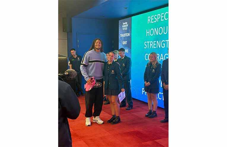 Students present Newcastle Knights players with hand-painted boots in honour of Indigenous Round. Photos: CMCC Facebook.