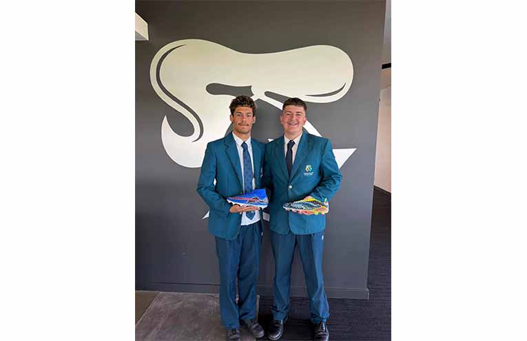 Students present Newcastle Knights players with hand-painted boots in honour of Indigenous Round. Photos: CMCC Facebook.