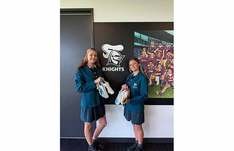 Students present Newcastle Knights players with hand-painted boots in honour of Indigenous Round. Photos: CMCC Facebook.
