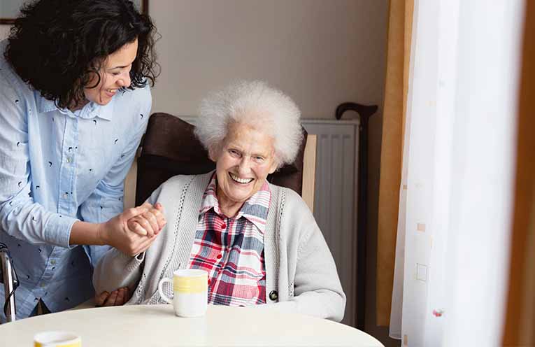 A senior woman receives care and assistance.